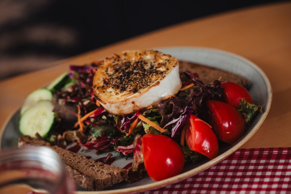 Grilled goat’s cheese on a colourful salad with tomatoes, cucumber and bread at Café Zeis.